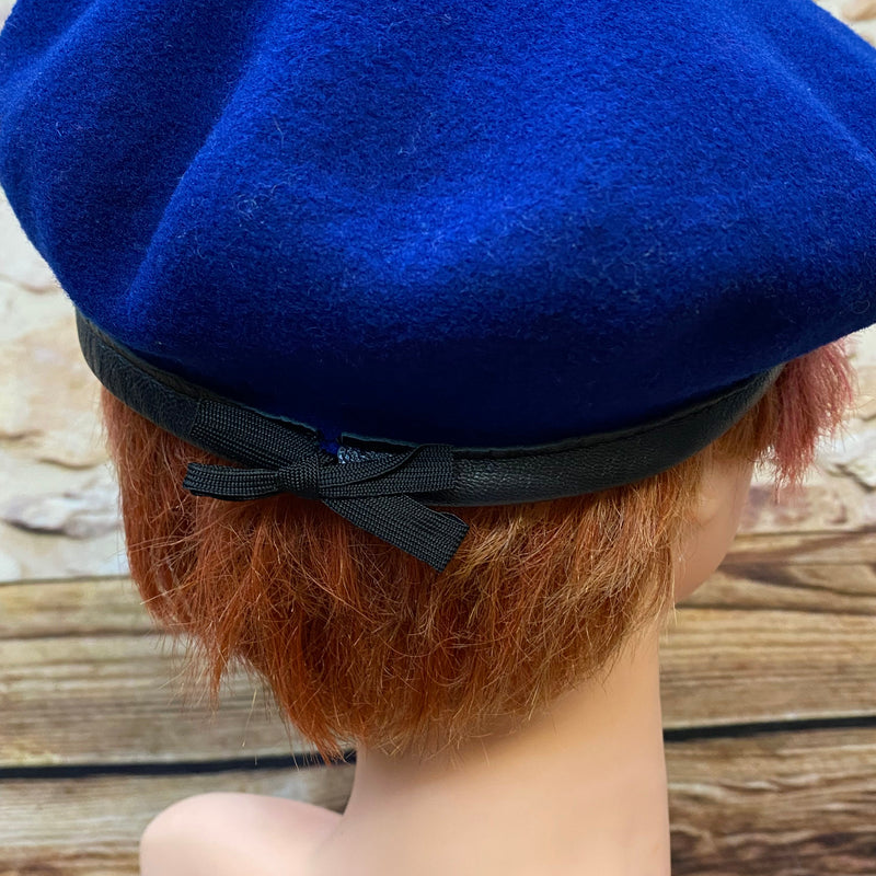 „Rückansicht blaues Vintage Barett mit schwarzer Schleife und Rand“