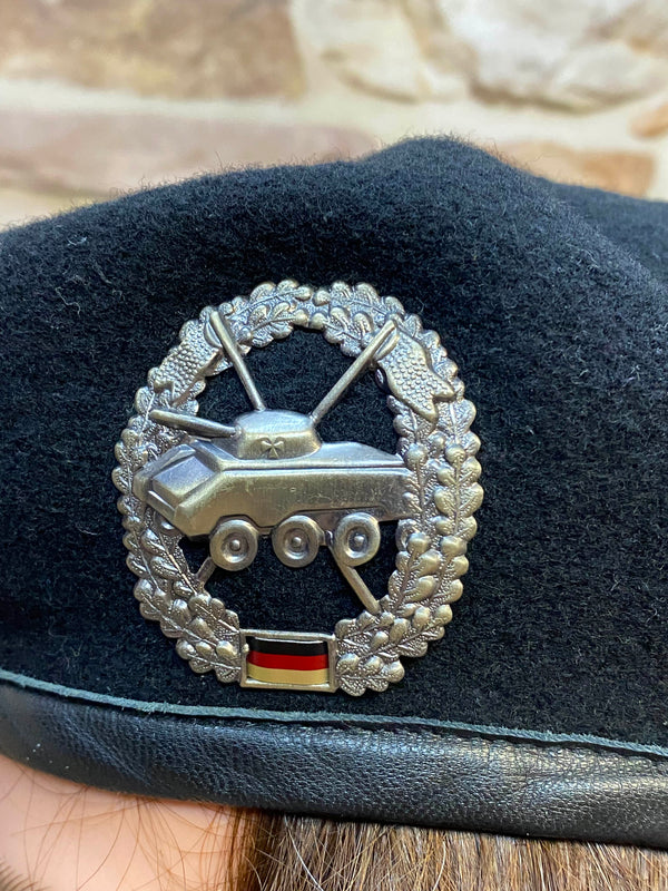 „Detailaufnahme vom silberfarbenen Panzer-Abzeichen auf schwarzem Vintage Uniform-Barett“