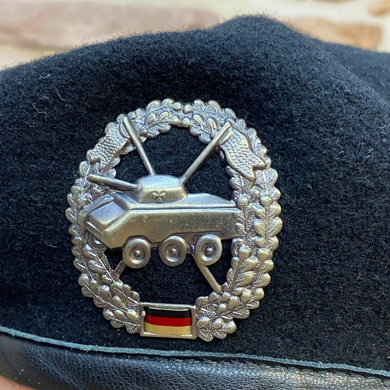 „Detailaufnahme vom silberfarbenen Panzer-Abzeichen auf schwarzem Vintage Uniform-Barett“