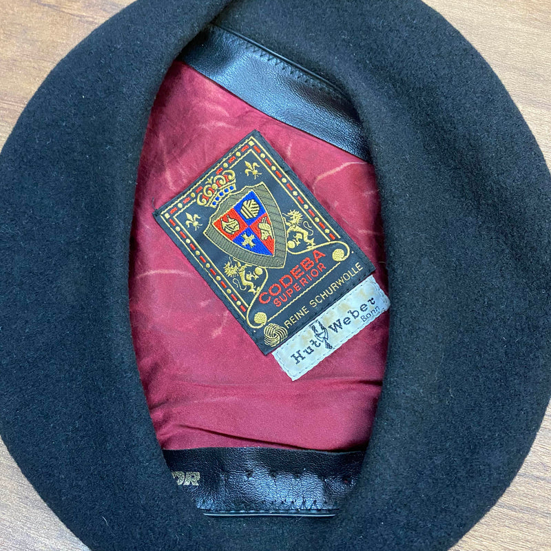 „Innenansicht eines schwarzen Vintage Baretts mit weinrotem Futter und Codeba Superior Label“