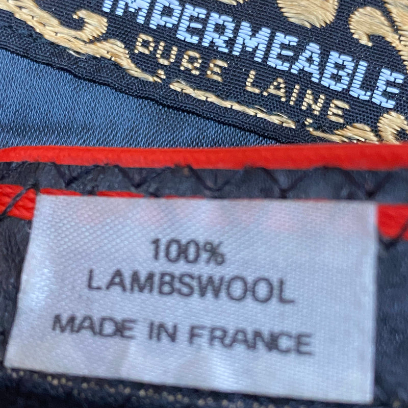 „Detailaufnahme vom Foulard Basque Label und 100 Prozent Lambswool Etikett im schwarzen Vintage Barett“
