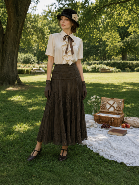 „Vintage Damen Outfit im nostalgischen Stil mit Rüschenbluse, langem Rock, Hut und Handschuhen bei Picknick im Park“