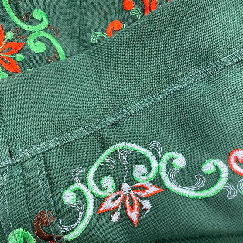 Detail der farbigen Stickerei am Rocksaum des grünen Vintage Dirndls