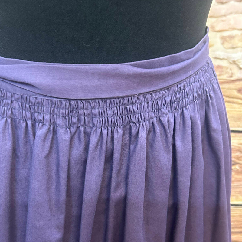„Detail gesmokter Bund einer lila Vintage Dirndl-Schürze aus Baumwolle“