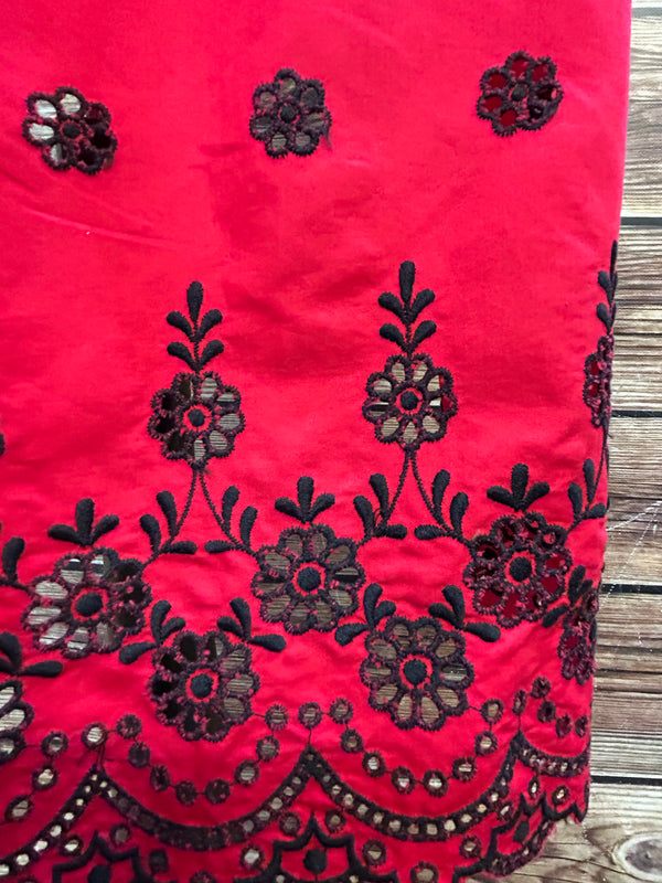 „Detail  rote Dirndl-Schürze mit Stickerei“