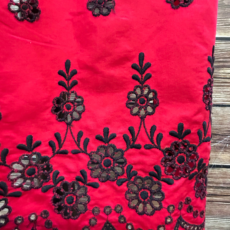 „Detail  rote Dirndl-Schürze mit Stickerei“