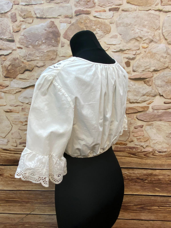 „Seitliche Ansicht einer weißen Vintage Dirndlbluse mit besticktem Ausschnitt“