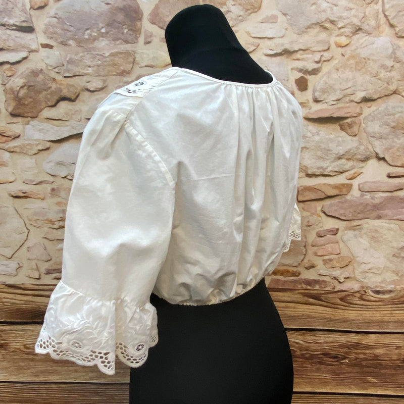 „Seitliche Ansicht einer weißen Vintage Dirndlbluse mit besticktem Ausschnitt“