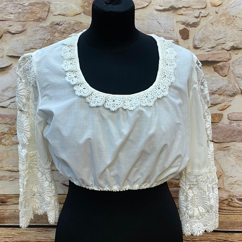 „Weiße Vintage-Dirndlbluse in Größe 40 mit langen, floralen Spitzenärmeln und rundem Spitzenausschnitt, vorne leicht gerafft und mit elastischem Bund