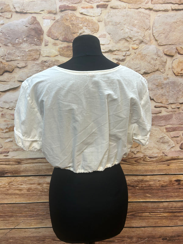 „Rückansicht einer weißen Vintage-Dirndlbluse mit elastischem Saum und kurzen Ärmeln“