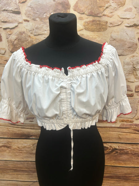 „Weiße Vintage-Dirndlbluse mit Karmelärmeln und roter Häkelbordüre auf Schneiderpuppe – Vorderansicht“