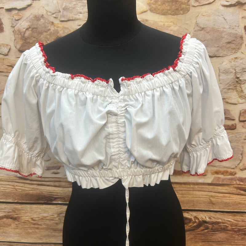 „Weiße Vintage-Dirndlbluse mit Karmelärmeln und roter Häkelbordüre auf Schneiderpuppe – Vorderansicht“