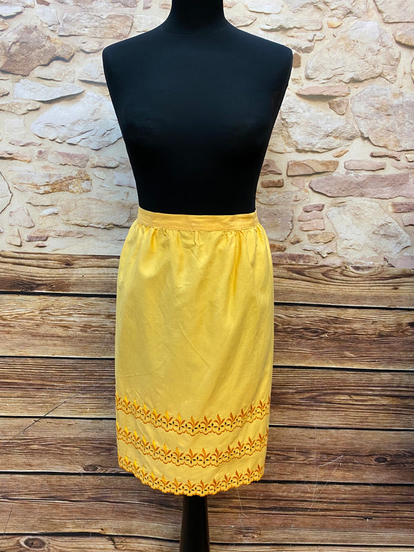 „Vintage Dirndlschürze gelb mit floraler Lochstickerei, Frontansicht“