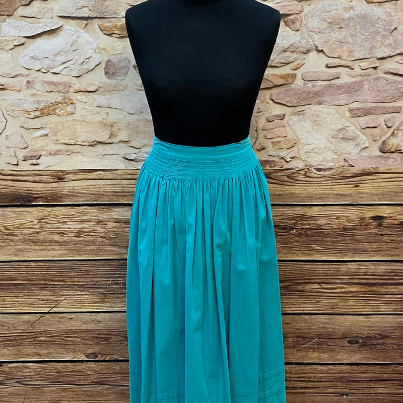 „Lange Vintage-Dirndlschürze in Petrol/Türkis mit Smokbund.“