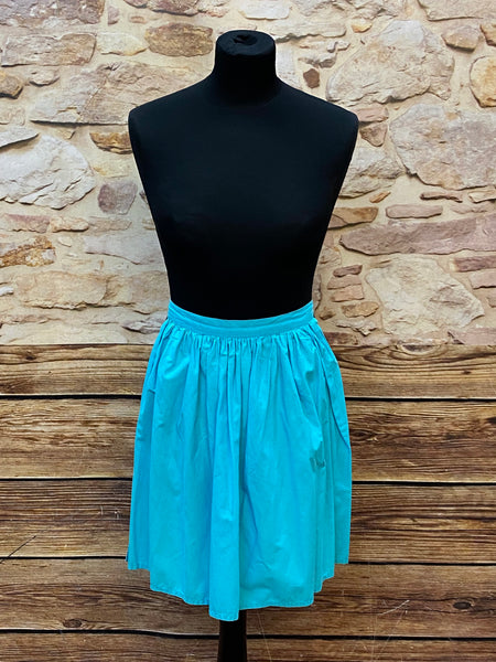 „Türkise Vintage-Dirndlschürze, kurz, mit gerafftem Bund und Bindebändern.“