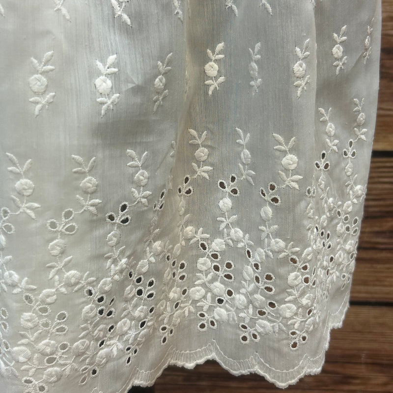„Detail Bund der weißen Vintage Dirndl-Schürze mit Raffung und Bindeband“