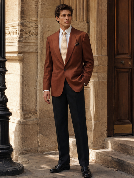 „Elegantes Herren Outfit mit braunem Vintage Sakko, weißem Hemd, beiger Krawatte, Einstecktuch und schwarzer Hose vor historischer Gebäudefassade“