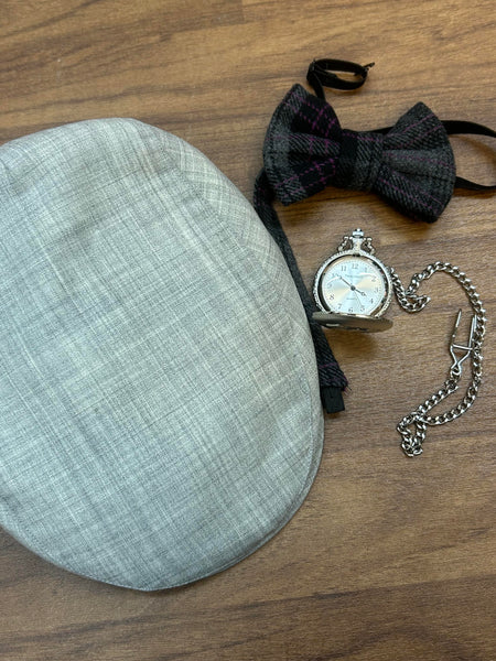 Set aus grauer Schiebermütze, handgemachter Fliege und silberner Taschenuhr.