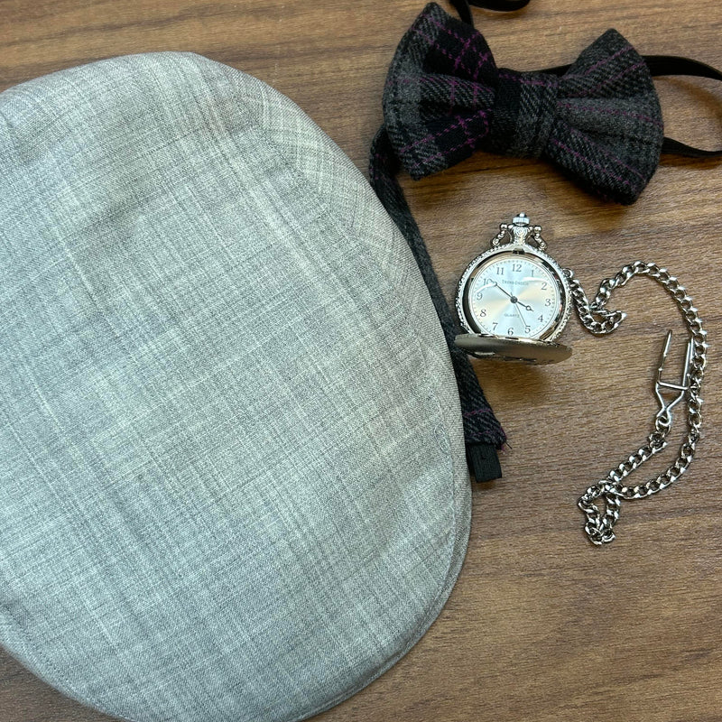 Set aus grauer Schiebermütze, handgemachter Fliege und silberner Taschenuhr.