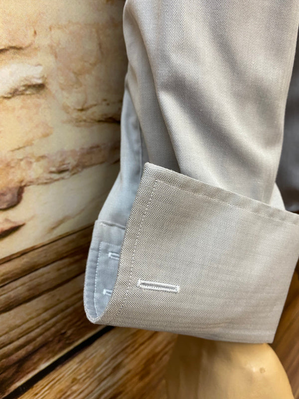 „Detailaufnahme des Umschlagmanschettenhemds mit silberfarbenen Manschettenknöpfen“