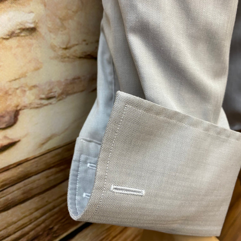 „Detailaufnahme des Umschlagmanschettenhemds mit silberfarbenen Manschettenknöpfen“