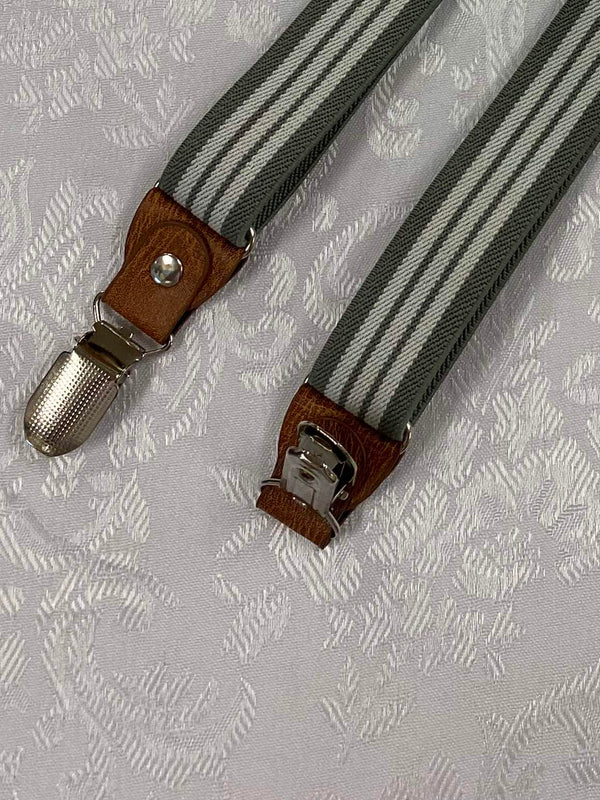 „Detailaufnahme Vintage Hosenträger mit braunem Lederbesatz und silberfarbenem Clip“