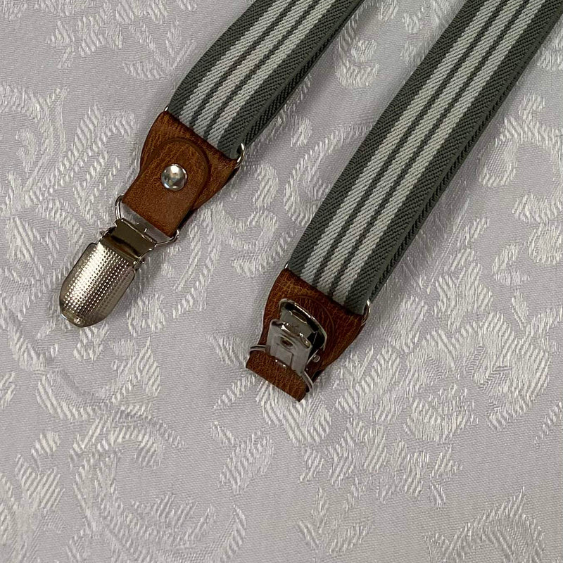 „Detailaufnahme Vintage Hosenträger mit braunem Lederbesatz und silberfarbenem Clip“