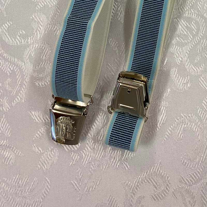 „Detailaufnahme hellblau gestreifte Hosenträger mit dekorativem Monogramm-Clip“
