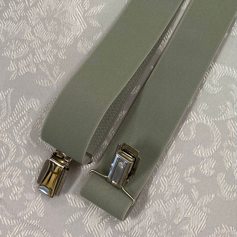 „Detailaufnahme Vintage Hosenträger hellgrün mit Metallclip und breitem elastischem Band“