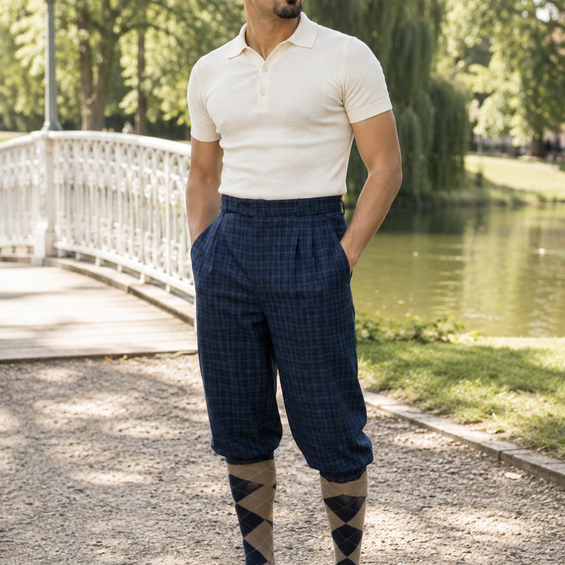 Vintage Knickerbocker Hose blau kariert im 20er Jahre Stil mit Poloshirt, Schiebermütze und Rauten-Kniestrümpfen im Park.