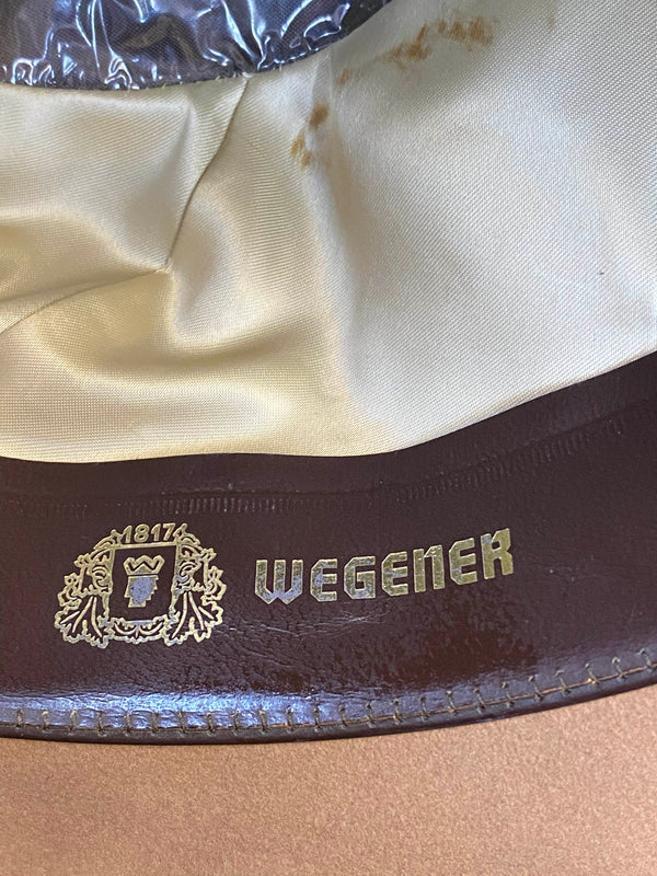 „Detailaufnahme vom Wegener Markenlogo im Inneren eines beigen Herren Huts“