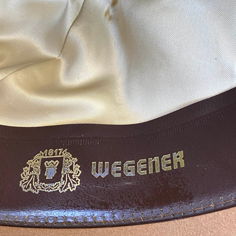 „Detailaufnahme vom Wegener Markenlogo im Inneren eines beigen Herren Huts“