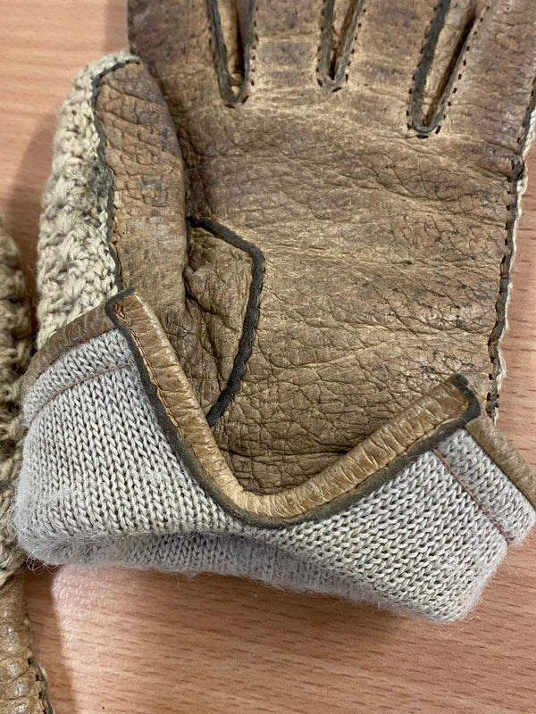 Detailaufnahme von Leder und Strick an braun-beigen Handschuhen