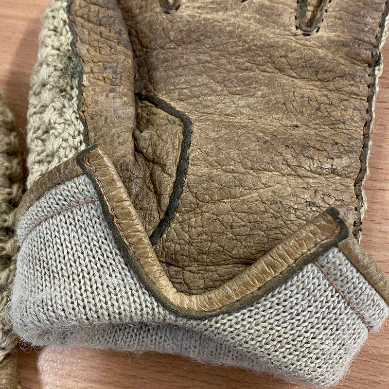 Detailaufnahme von Leder und Strick an braun-beigen Handschuhen