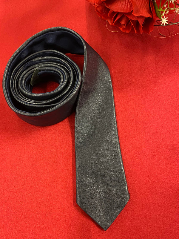 „Vintage Lederkrawatte dunkelbraun aus echtem Leder auf rotem Hintergrund“