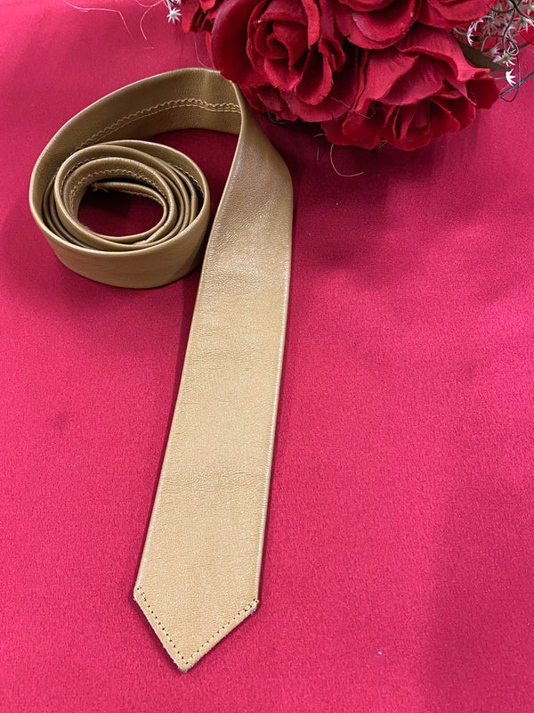 „Beige Lederkrawatte Vintage gerollt auf rotem Hintergrund“