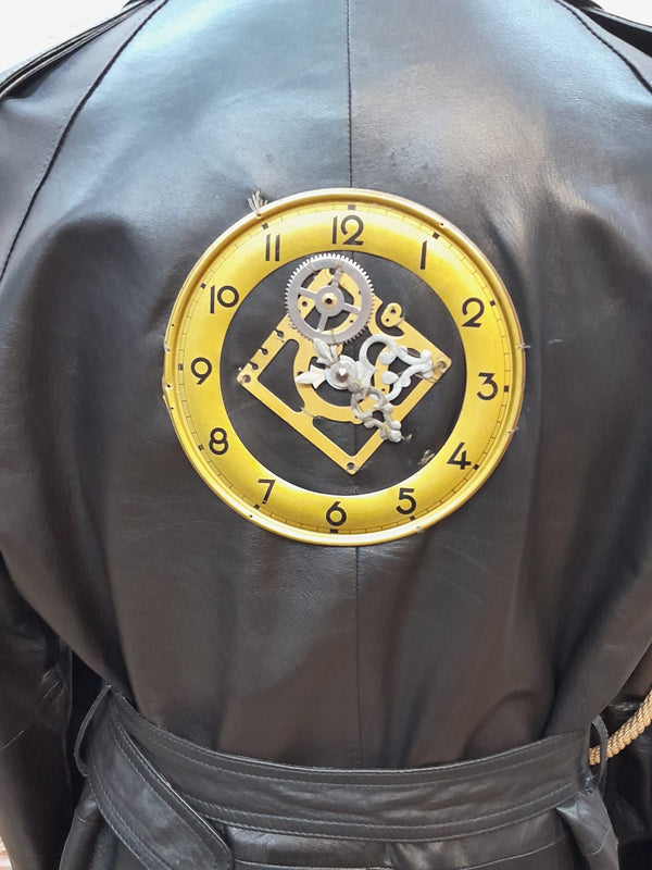 Detailaufnahme Uhr-Applikation mit Zahnrädern am Rücken des Ledermantels