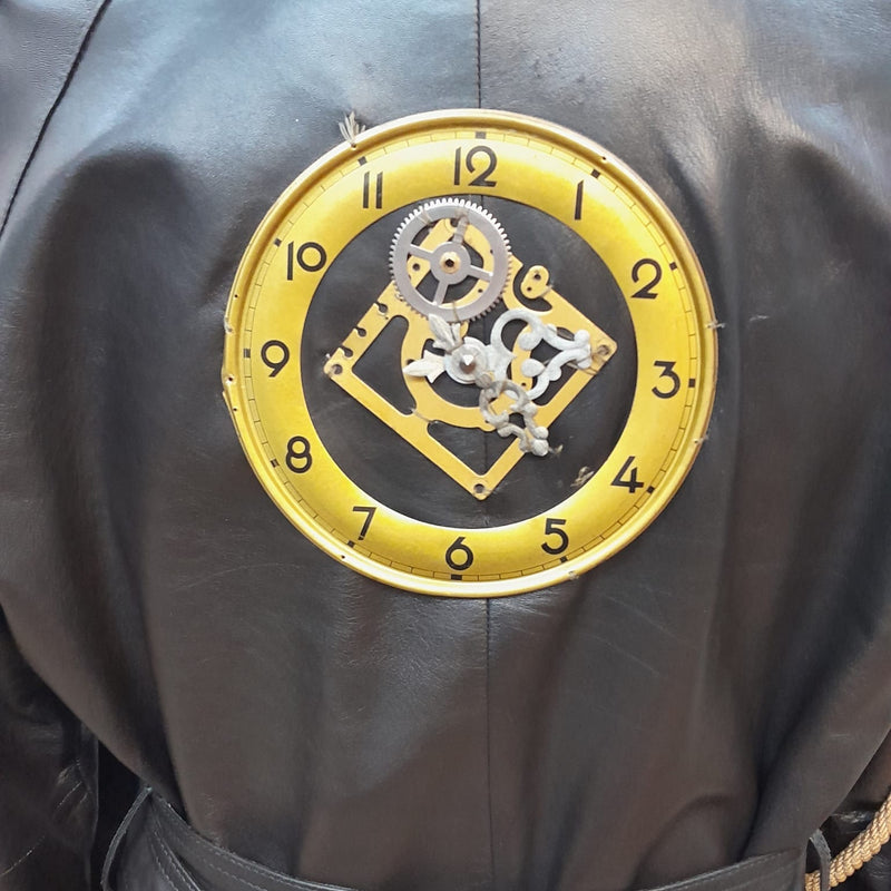 Detailaufnahme Uhr-Applikation mit Zahnrädern am Rücken des Ledermantels