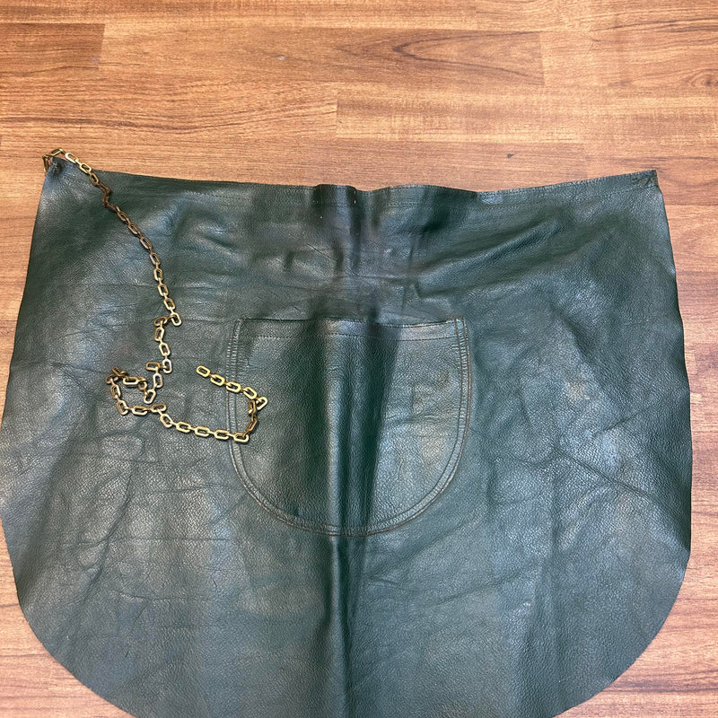 Vorderansicht einer dunkelgrünen vintage Lederschürze mit Tasche und Kette.