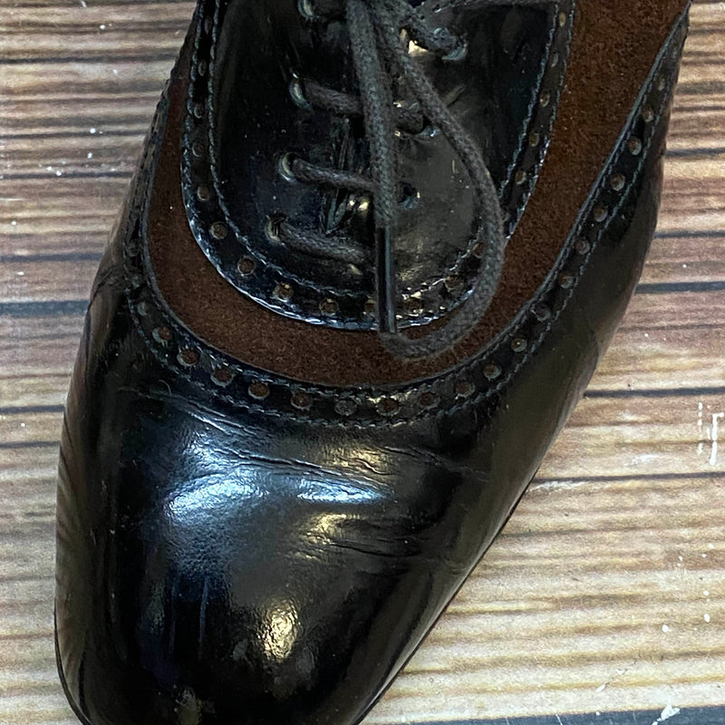 Detailaufnahme schwarzer Lackleder-Schuh mit braunem Einsatz