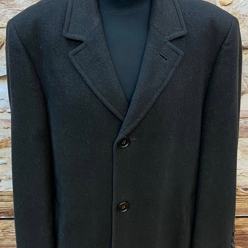 „Detailansicht vom schwarzen Vintage Herrenmantel mit Reverskragen und Knopfleiste“