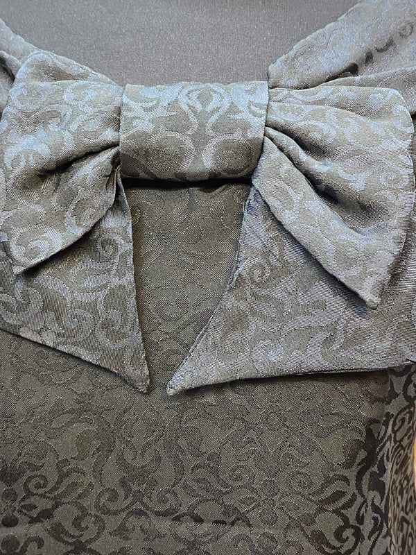 „Detailaufnahme der großen Schleife am schwarzen Vintage 50er Jahre Oberteil“