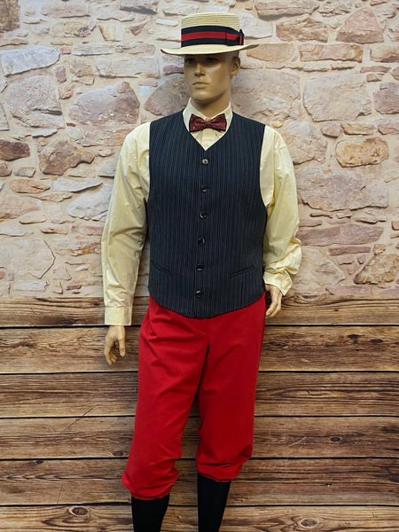 Vintage 1920er Oldtimer-Herren-Outfit am Schaufenster: Hemd, Nadelstreifen-Weste, rote Knickerbocker-Hose, Strohhut und Fliege.