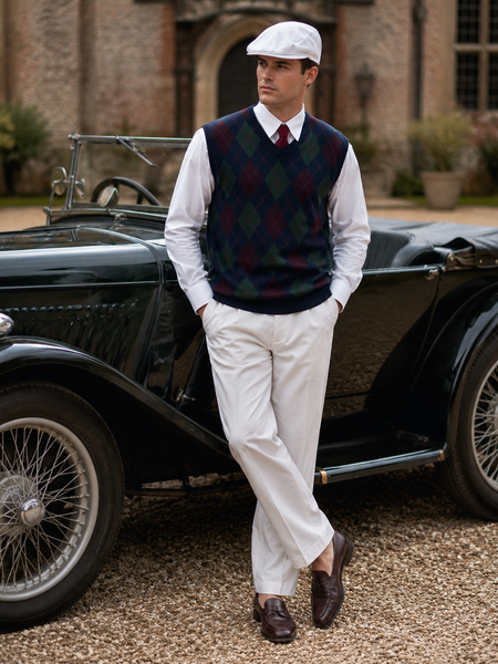 „Vintage Unikat Oldtimer Outfit für Herren mit weißer Schiebermütze, weißem Hemd, gemusterter Pullunderweste, Strickkrawatte und heller Hose“