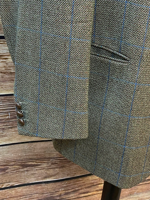 Detailaufnahme des Ärmels mit blauem Karomuster und Knöpfen