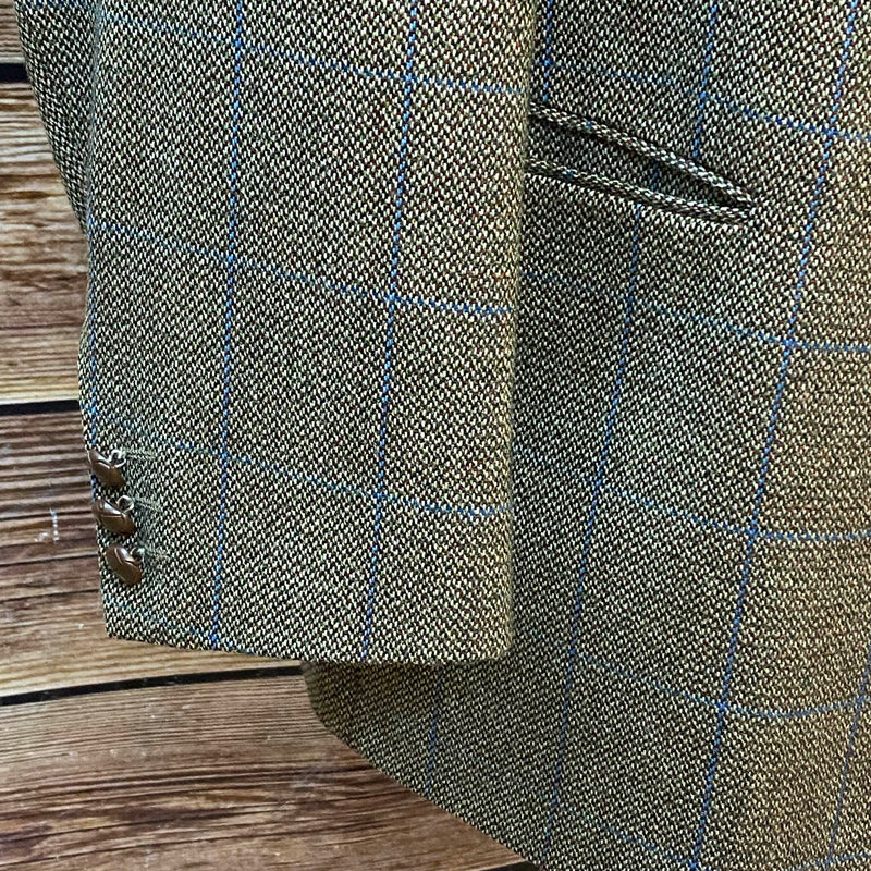 Detailaufnahme des Ärmels mit blauem Karomuster und Knöpfen