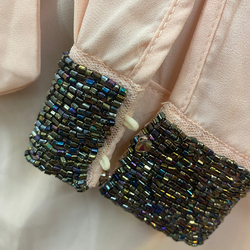 „Detailaufnahme Vintage Schluppenbluse mit funkelnden Perlen an den Manschetten“
