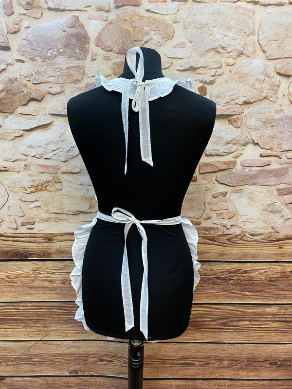 „Detailansicht Rückenbindung einer weißen Vintage-Schürze mit Rüschen“