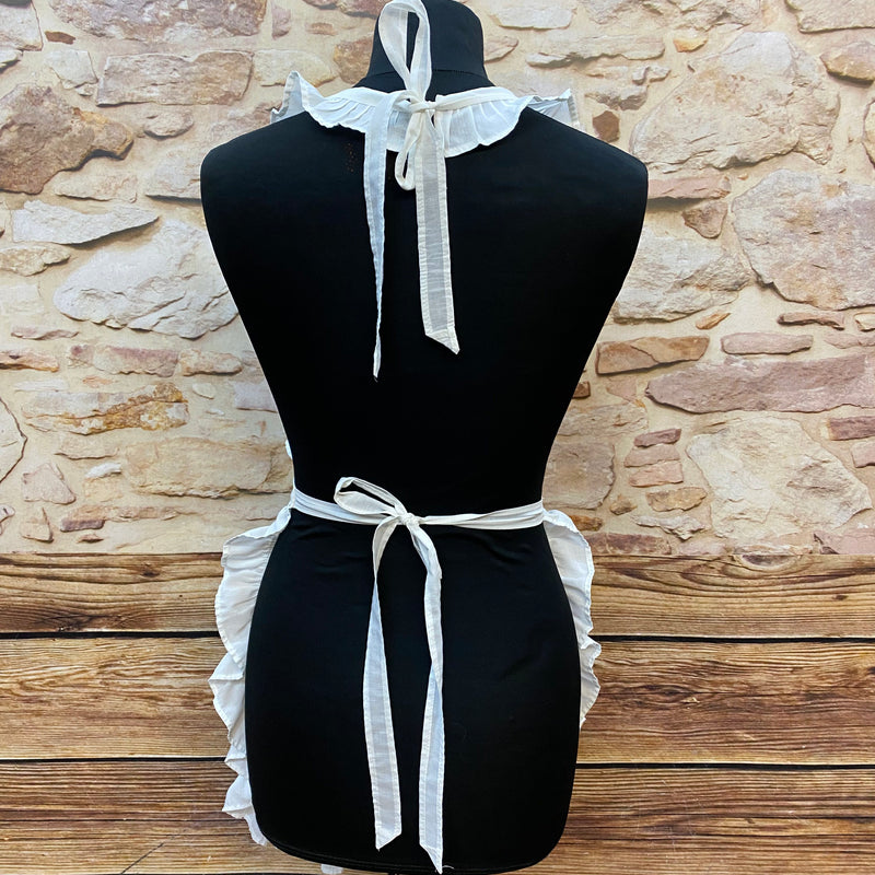 „Detailansicht Rückenbindung einer weißen Vintage-Schürze mit Rüschen“