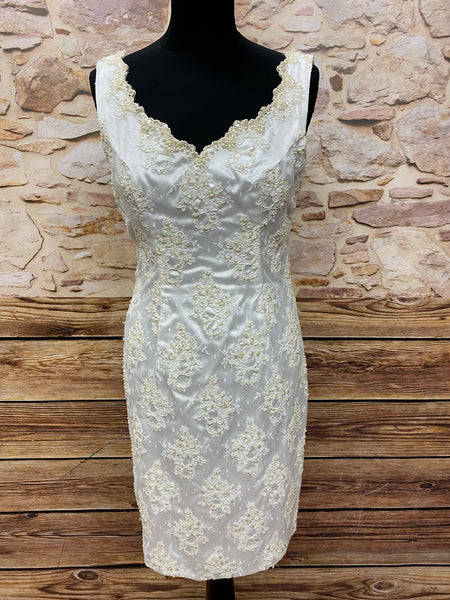 „Kurzes ivoryfarbenes Vintage-Cocktailkleid in Größe 38 mit Perlen- und Spitzenapplikationen, taillierter Schnitt, Rückenschlitz, ungetragen, sehr guter Zustand.